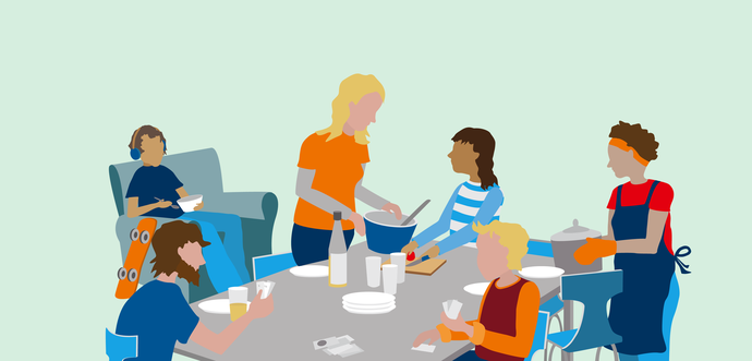 Mehrere Erwachsene und Kinder sitzen zusammen an einem Tisch und essen.